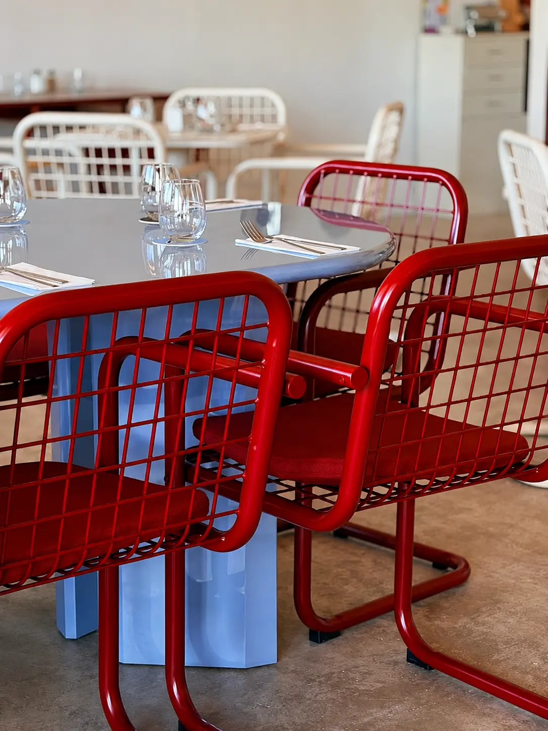 La salle du restaurant — chaises rouges et tables bleues